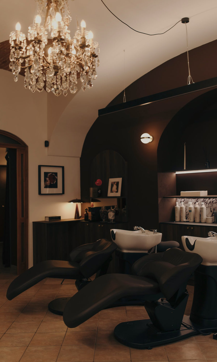 Le postazioni lavaggio con i lettini reclinabili sotto il lampadario dello studio di Bra